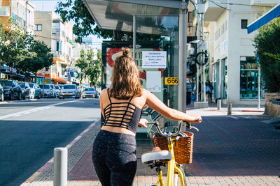 Woman riding bicycle on street in city