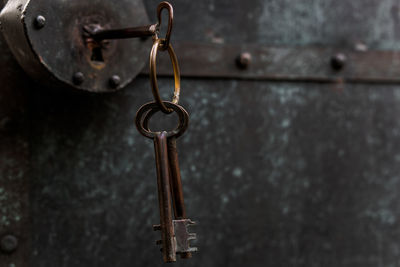 Close-up of keys hanging on metallic padlock