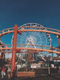 Low angle view of rollercoaster against sky at night