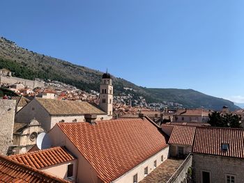 High angle view of buildings in city against clear blue sky