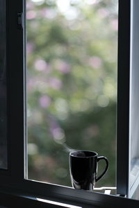 Close-up of coffee cup on window