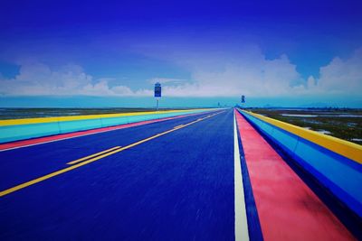 Multi colored umbrella on road against blue sky