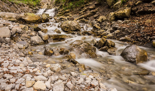 High angle view of stream flowing through rocks