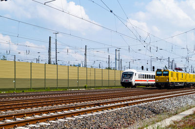 Modern train by cables against sky