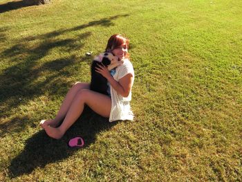 Full length of girl sitting on grassy field