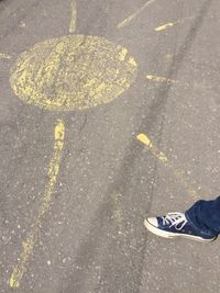 Low section of man standing on road