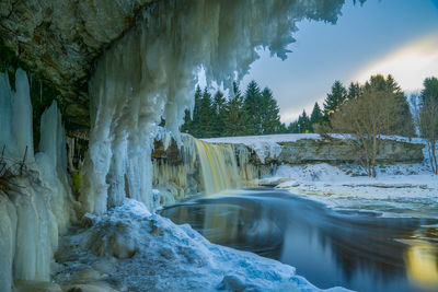 Scenic view of waterfall against sky during winter