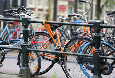 Orange bike with big padlock on an amsterdam bridge