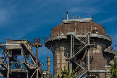 Low angle view of factory against blue sky