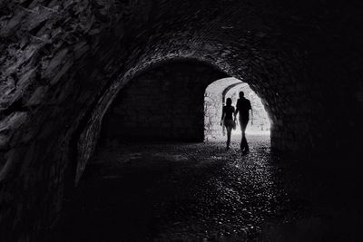 Rear view of people standing in tunnel