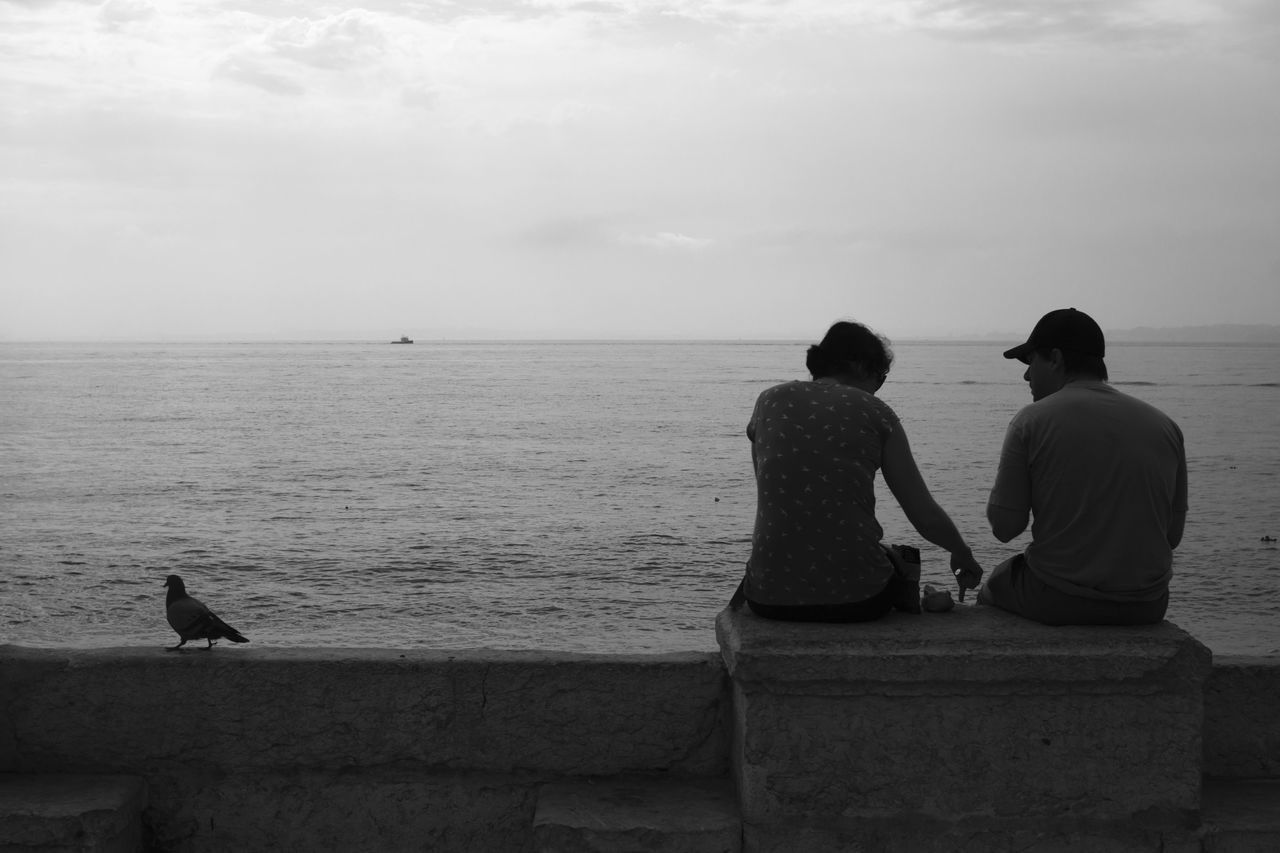 sea, horizon over water, water, sky, rear view, men, tranquil scene, tranquility, lifestyles, scenics, leisure activity, nature, beauty in nature, standing, sitting, person, relaxation, cloud - sky