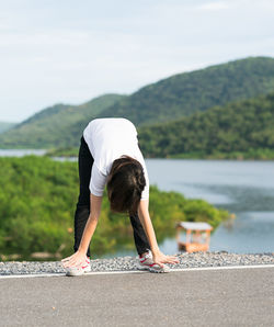 Teenage girl bending against mountain