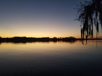 Scenic view of lake against clear sky during sunset