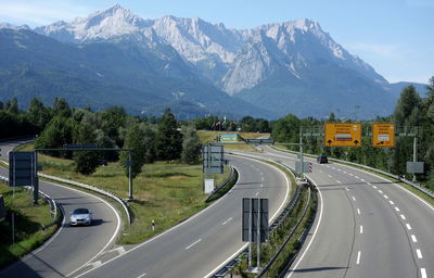 Road leading towards mountains against sky