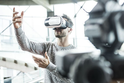 Tech developer wearing virtual reality headset at robotic workshop