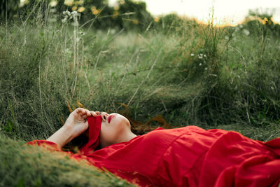 Midsection of woman relaxing on field
