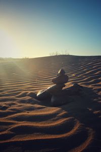 Shadow of person sitting on sand