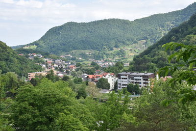 Scenic view of townscape and mountains against sky