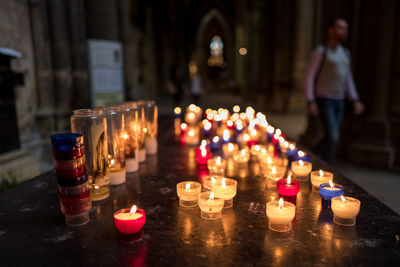 Lit tea light candles on table in metz cathedral