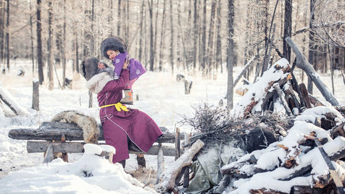 Woman in snow covered forest