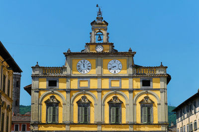 Low angle view of clock tower against blue sky