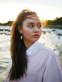 Portrait of beautiful woman standing by lake