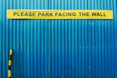 Low angle view of information sign on wall