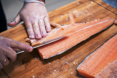 Cropped hand of person preparing food on cutting board