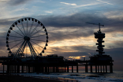 Low angle view of silhouette ferris wheel against sky at sunset