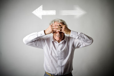 Portrait of man wearing mask against gray background