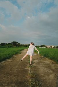 Woman standing on field against sky
