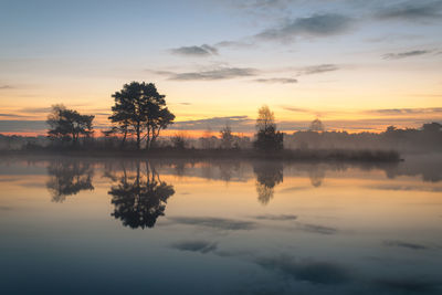 Beautiful misty morning with nice colors in the sky and great refelctions on the lake. t