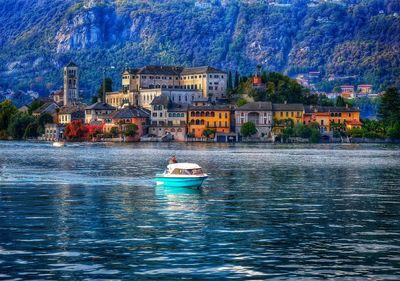 Boats in sea against buildings in city