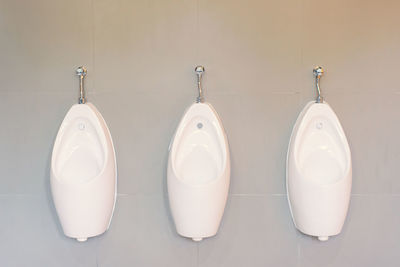 Close-up of urinals on wall