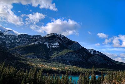 Scenic view of lake by mountains against sky