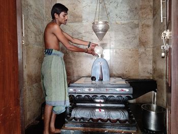 Side view of man worshiping at temple