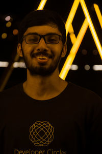 Portrait of young man standing against wall