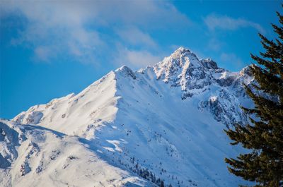 Low angle view of snowcapped mountains against sky