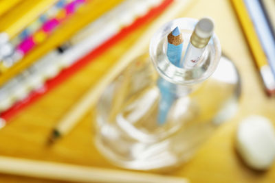 Wooden work desk with colored pencils ,  pencil box with blue pencil and pencil eraser   