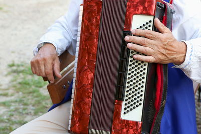 Midsection of man playing accordion
