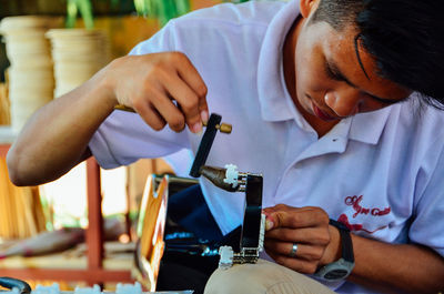 Midsection of man working on table