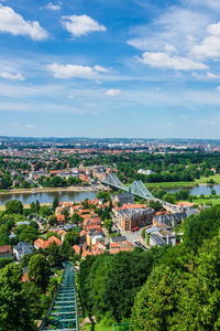 Aerial view of trees and buildings in city against sky