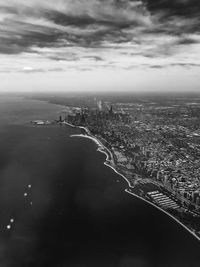 Aerial view of cityscape against cloudy sky