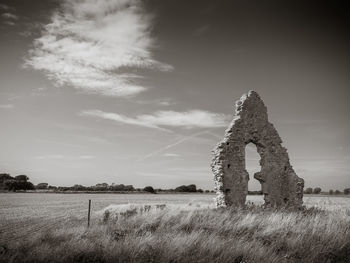 Old ruin on field against sky