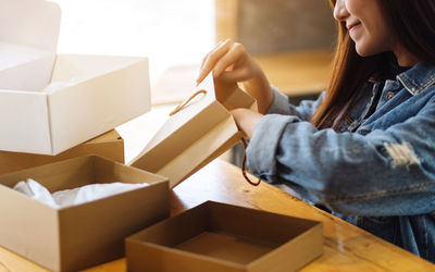 Midsection of woman holding cardboard box