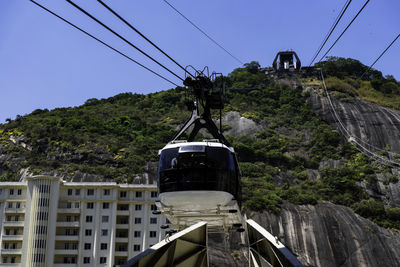 Low angle view of overhead cable car against sky