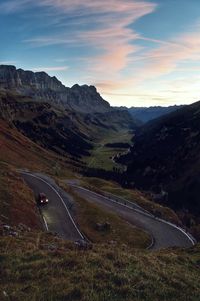 Lonely car in the early morning on a nice road through the swiss mountains