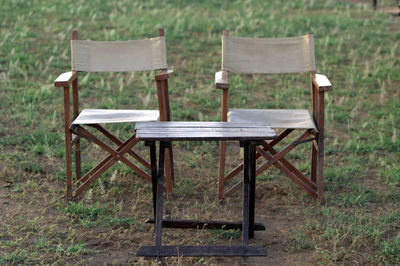 Empty foldable chairs and table on field