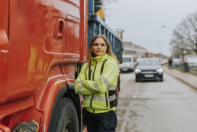 Portrait of female construction worker standing next to truck