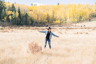 Full length of young girl standing on field during autumn